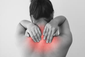 Woman with pain in back or neck