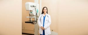 Smiling Female Doctor Next to Mammogram